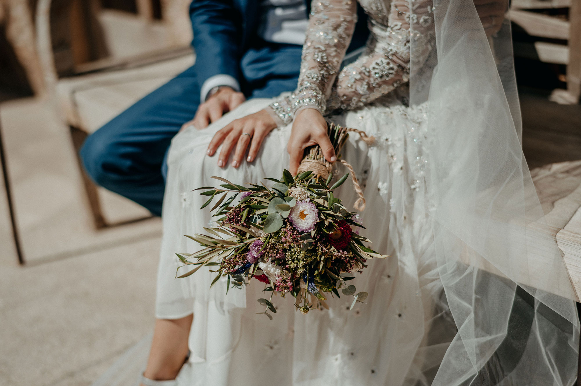 Dettaglio di una sposa con bouquet durante un evento elegante in Sardegna, espressione di stile e raffinatezza