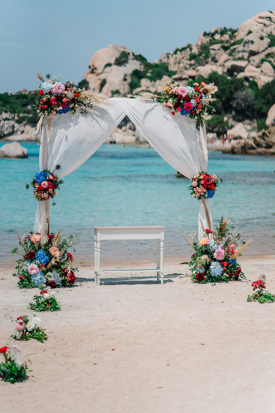 Arco floreale allestito sulla spiaggia con vista sul mare dell’Arcipelago della Maddalena