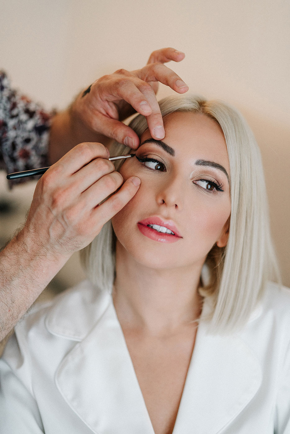 Make-up artist al lavoro durante la preparazione della sposa prima del matrimonio